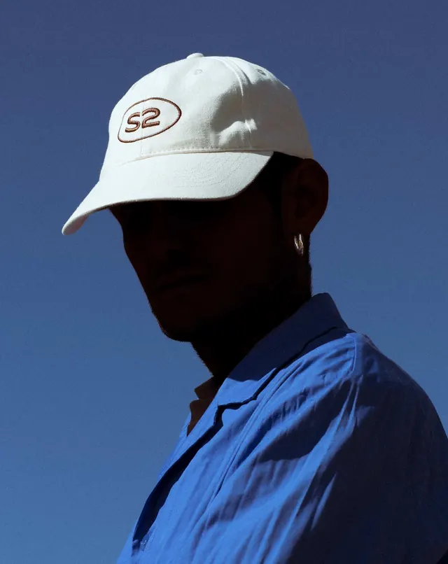 Person Wearing White Cap with Logo, photographic, minimal, vibrant