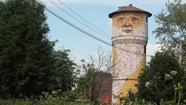 Surrealist Face Mural on Cylindrical Structure, illustrated, retro, muted