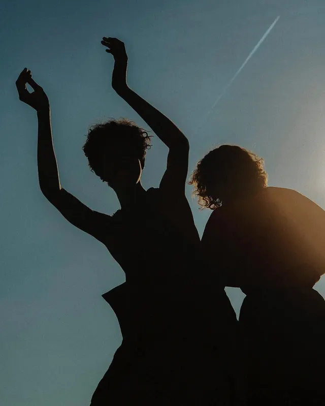 Silhouette of Two People Against Blue Sky, minimal, photographic, high-contrast