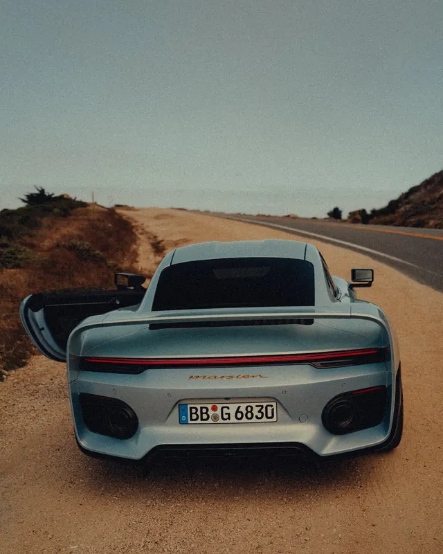 Modern Sports Car on Coastal Road, photographic, luxury, muted