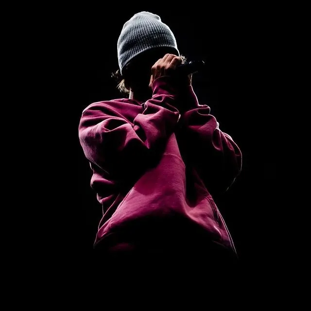 Person in Beanie with Microphone, dark-mode, photographic, dark