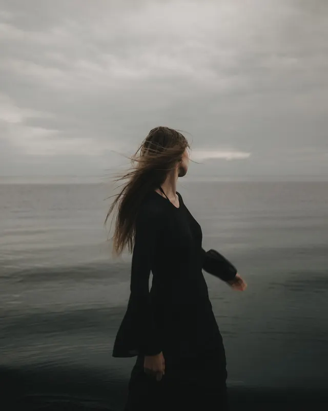 Woman in Long Coat by the Sea, minimal, photographic, monochrome