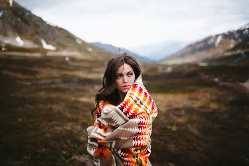 Woman in Patterned Sweater in Mountain Landscape, photographic, organic, earthy