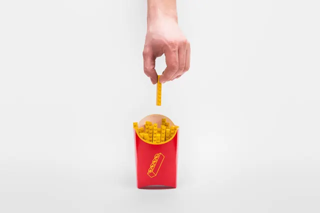 Hand Holding French Fry Container, minimal, photographic, vibrant