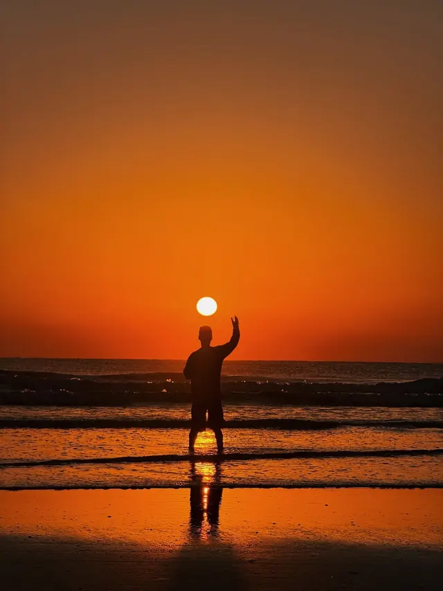 Silhouette of a Man Holding the Sun, photographic, minimal, warm