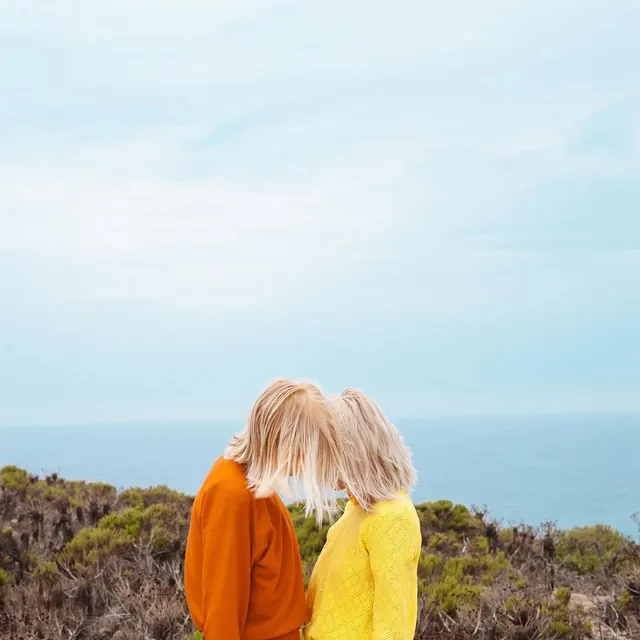 Two Women in Bright Sweaters on a Beach, minimal, photographic, vibrant