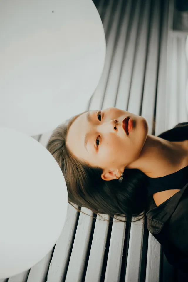 Close-up Portrait of a Woman on Slatted Surface, minimal, photographic, light