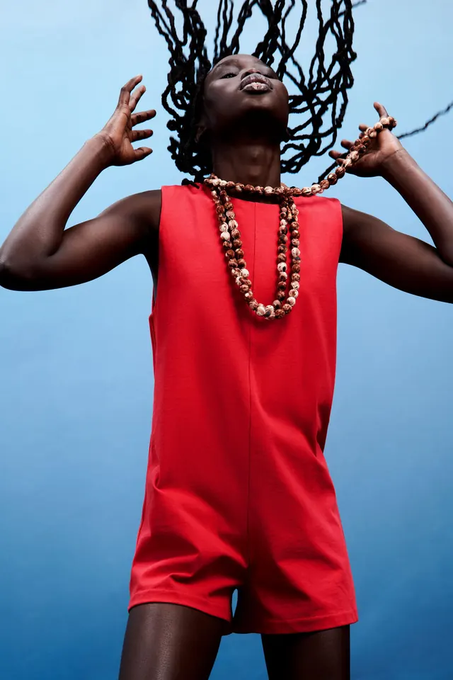 Man in Red Jumpsuit with Jewelry, photographic, maximalist, vibrant