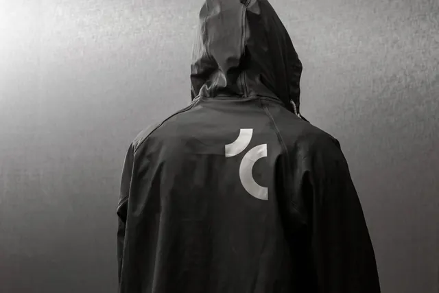 Hooded Figure with Abstract Circular Logo, minimal, monochrome, monochrome