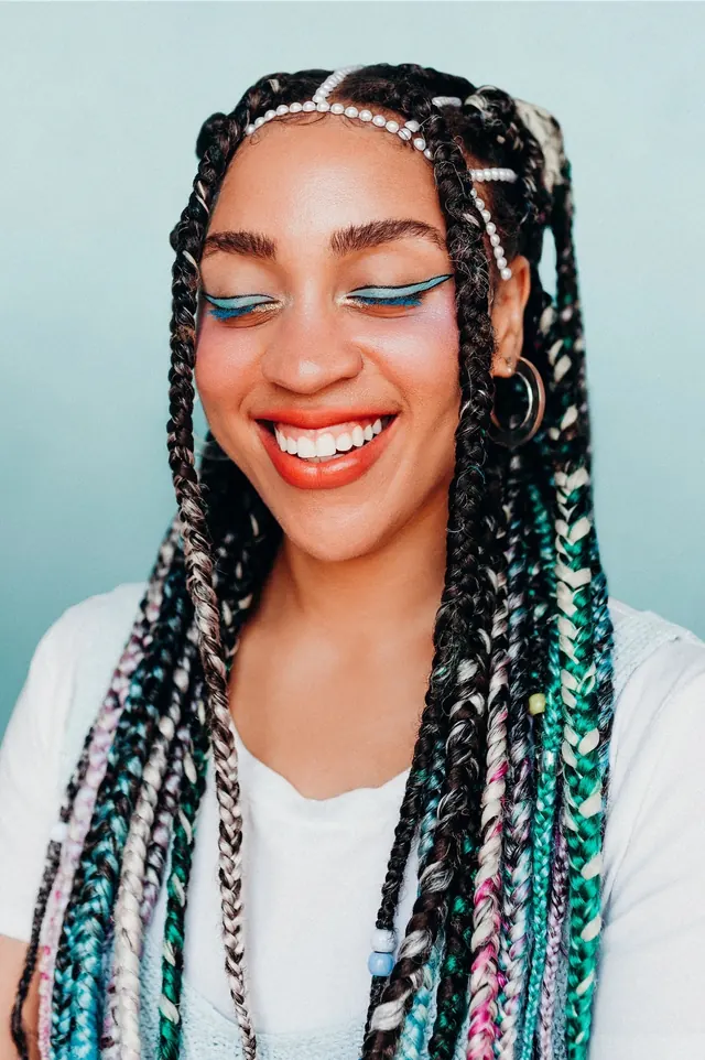 Portrait of a Woman with Braided Hair and Blue Eye Makeup, photographic, vibrant