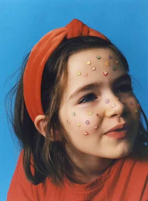 Portrait of a Girl with Face Stickers, photographic, playful, vibrant