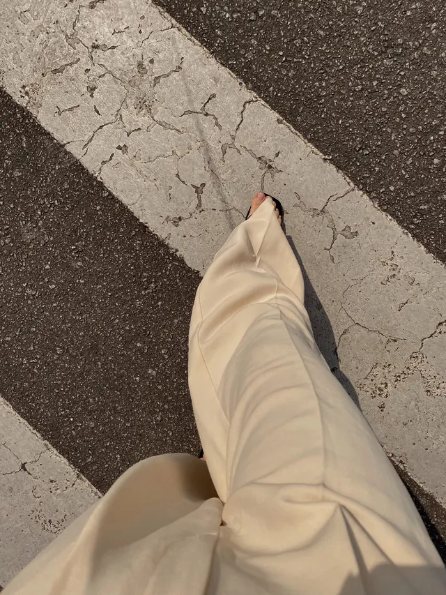 Person in Cream Trousers on Asphalt, minimal, photographic, muted