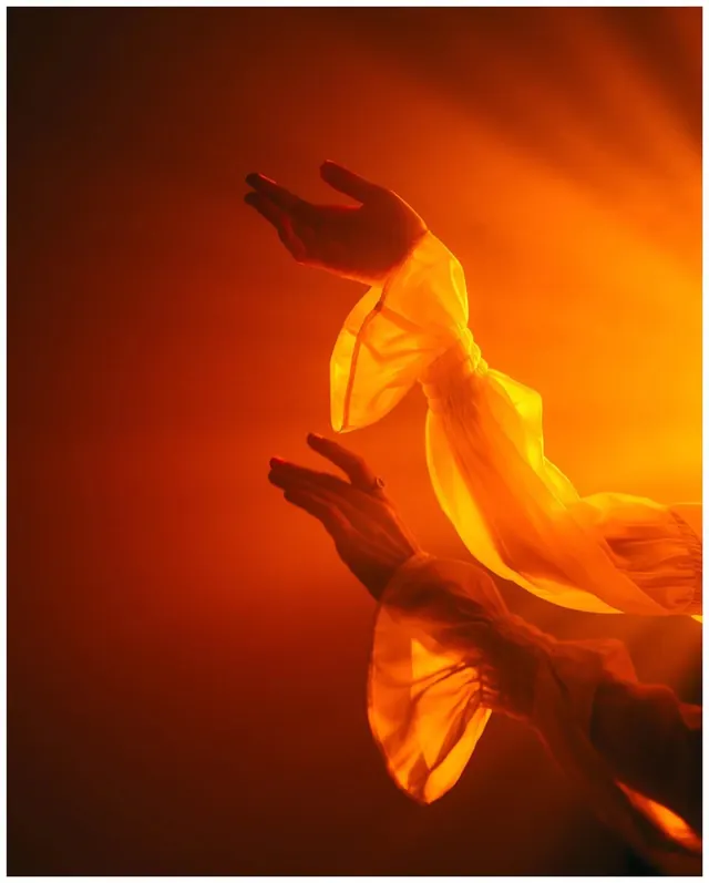 Glowing Hands in Orange Light, photographic, organic, warm