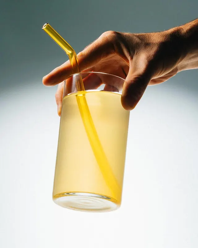 Hand Holding a Glass of Juice, minimal, photographic, vibrant
