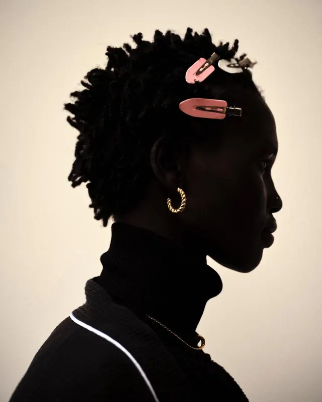 Portrait of a Person with Braided Hair and Accessories, photographic, minimal, dark