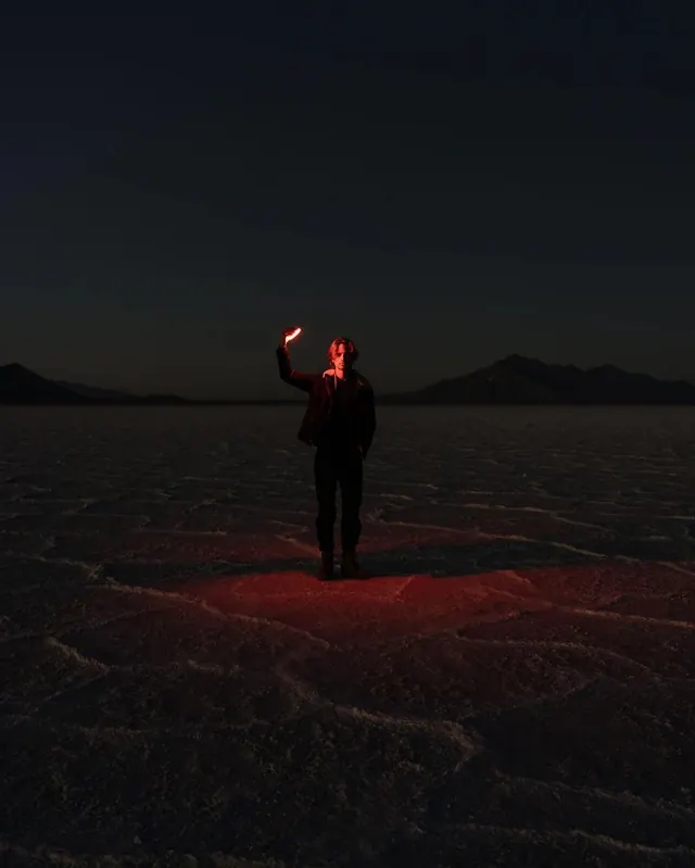 Person Holding Glowing Orb in Desert, minimal, photographic, dark