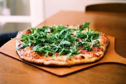 Pizza with Arugula on Wooden Board, photographic, organic, warm