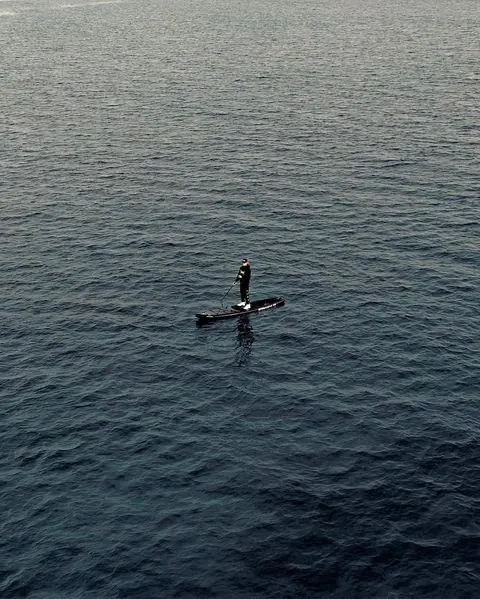 Person in a Small Boat on Open Water, minimal, photographic, cool