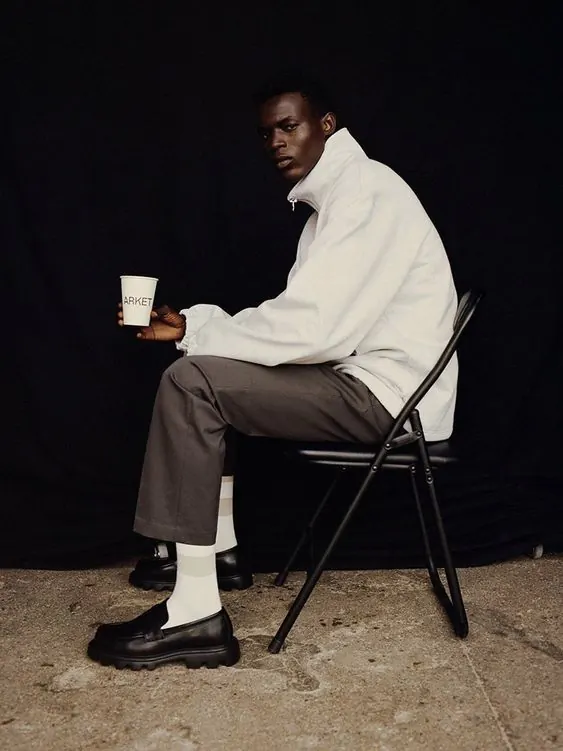 Man Sitting on Stool Holding Mug, minimal, photographic, dark