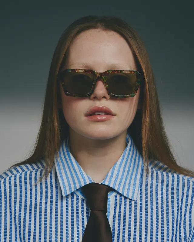 Portrait of a Woman in Striped Shirt with Sunglasses, photographic, minimal, high-contrast