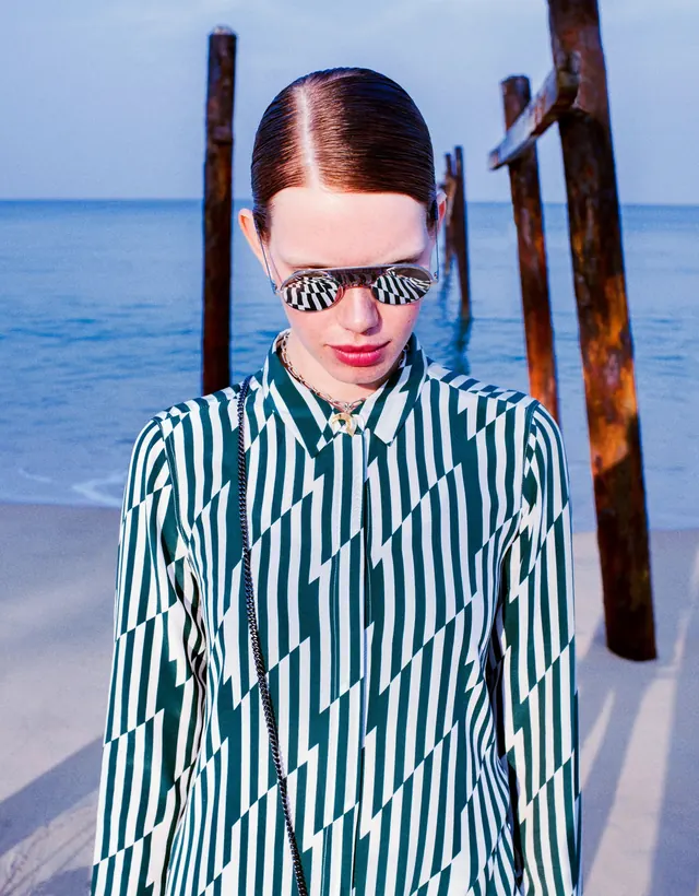 Woman in Striped Shirt on Beach, photographic, minimal, vibrant