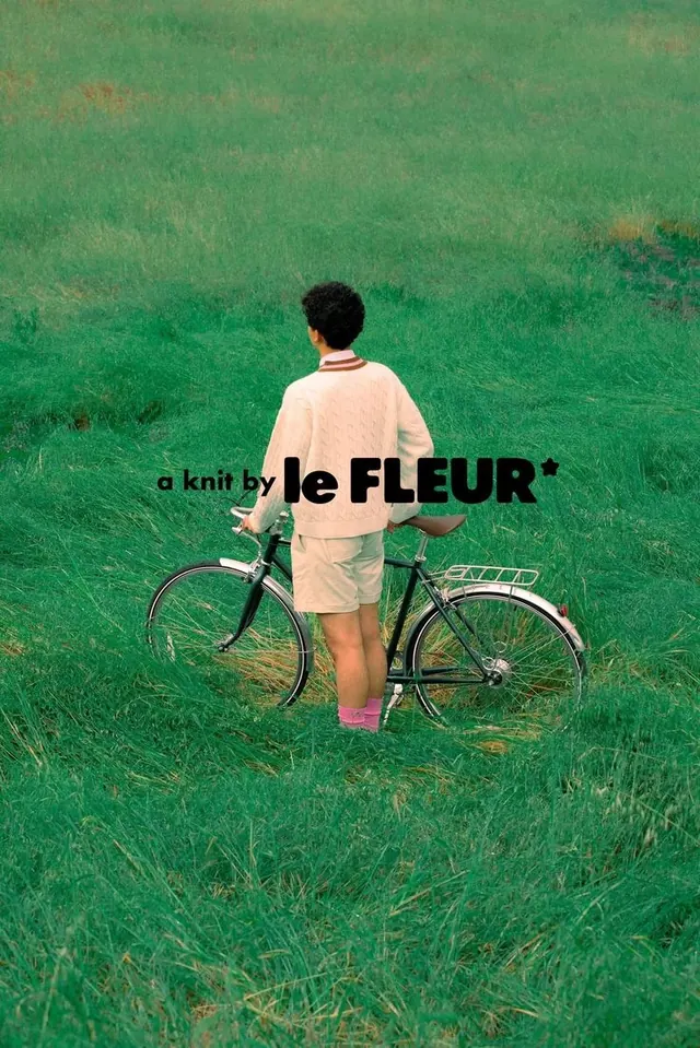 Man on Bicycle in Field with Text Overlay, photographic, minimal, vibrant