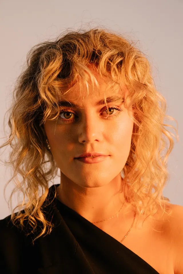 Portrait of a Woman with Curly Blonde Hair, photographic, organic, warm