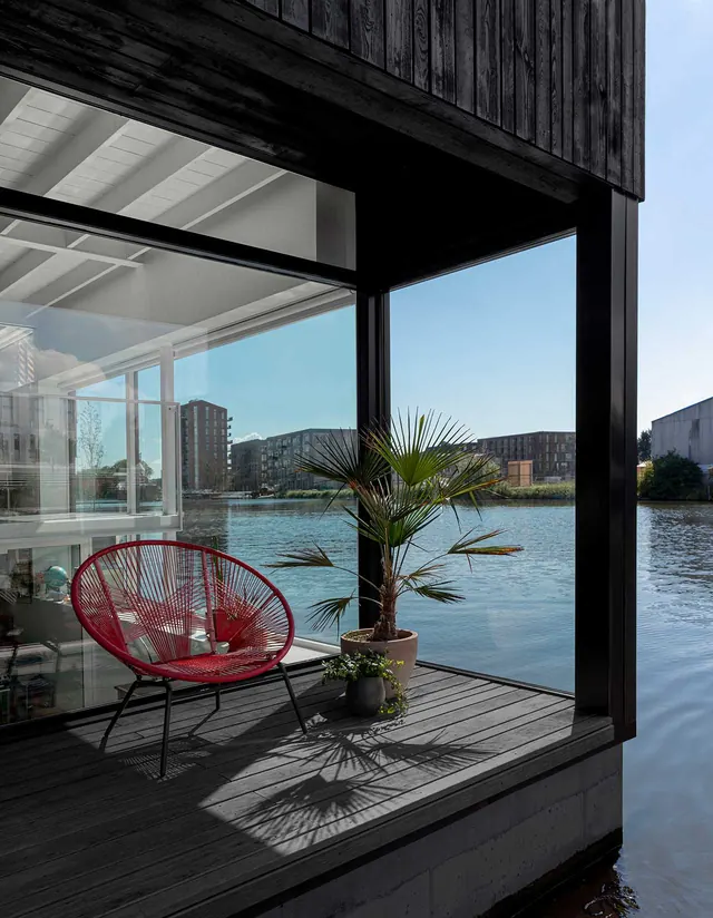 Modern Waterfront Interior with Red Lounge Chair, minimal, photographic, high-contrast