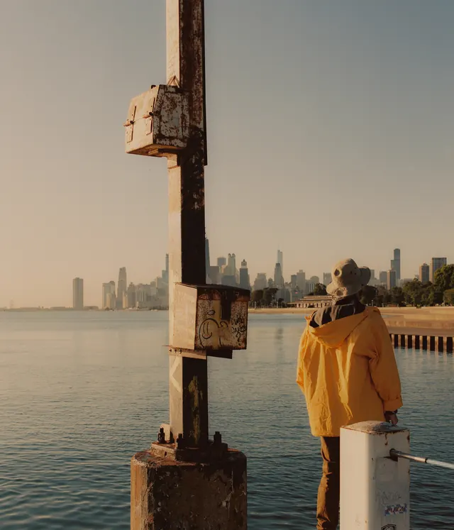 Person on Pier with Cityscape, photographic, minimal, warm