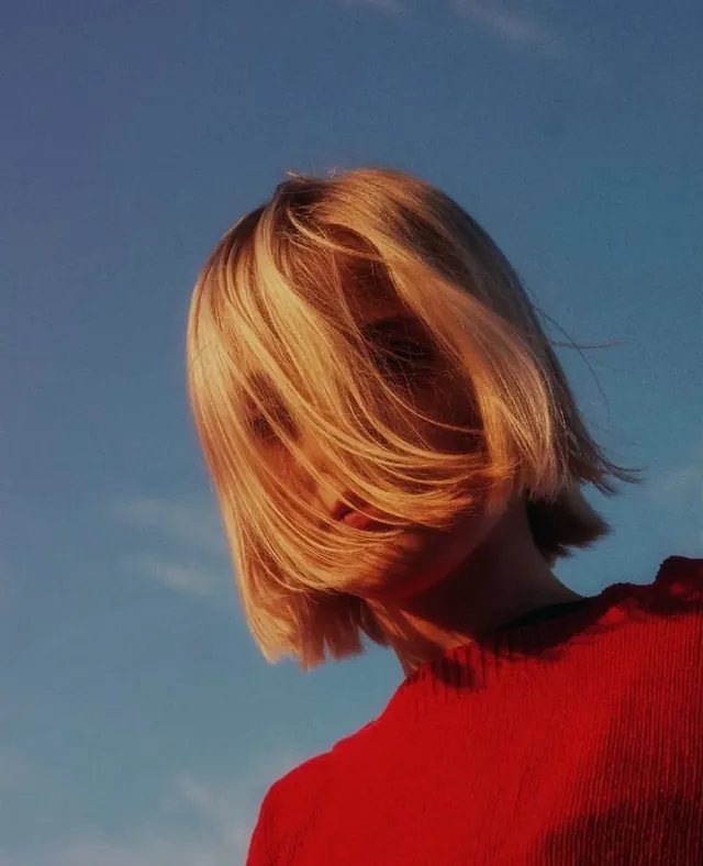 Profile of a Blonde Woman in Red, photographic, minimal, vibrant