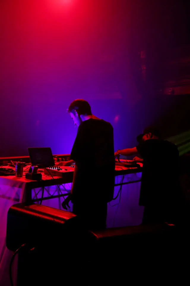DJ Performance in Neon Lighting, photographic, dark-mode, vibrant