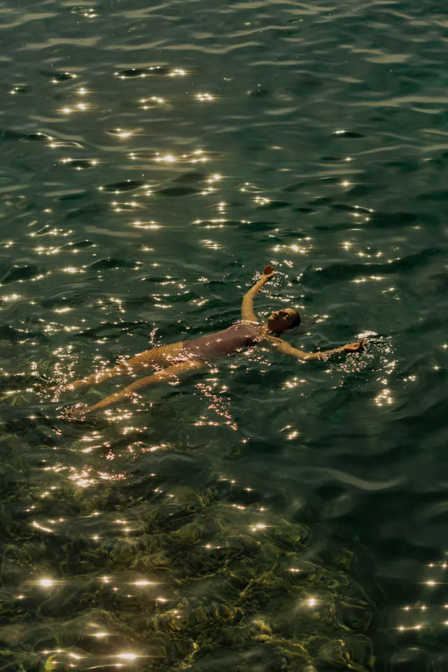 Woman Swimming in Sunlit Water, photographic, organic, warm