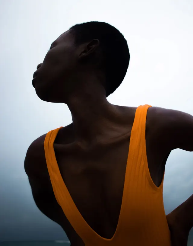 Profile of a Person in Orange Tank Top, minimal, photographic, high-contrast
