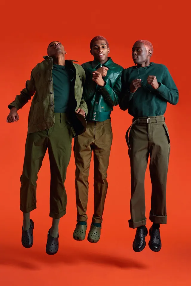 Three Men in Casual Attire Against Orange Background, photographic, minimal, vibrant