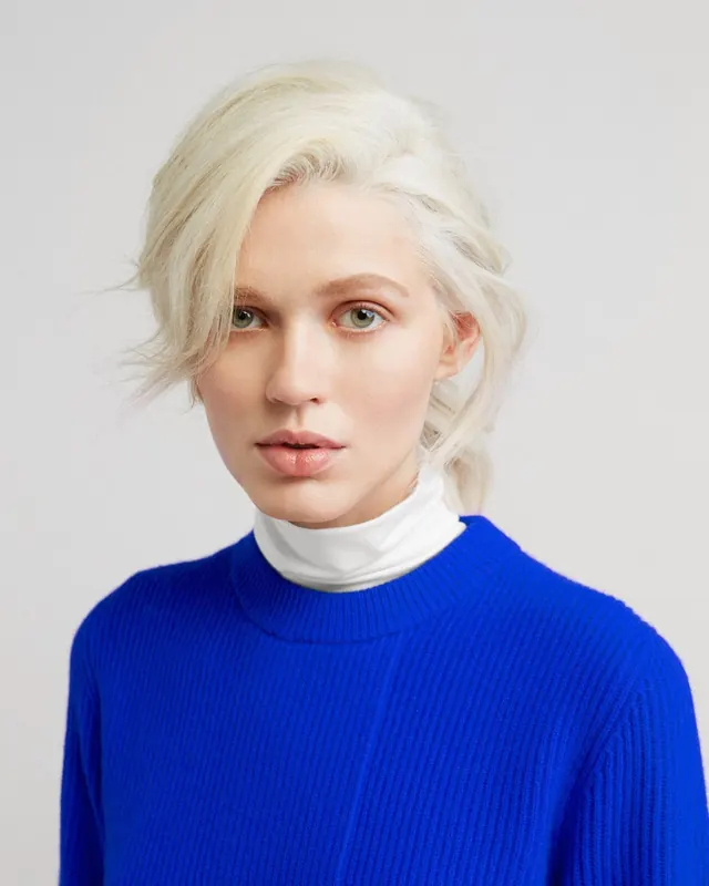Portrait of a Woman in Blue Knitwear, photographic, minimal, vibrant