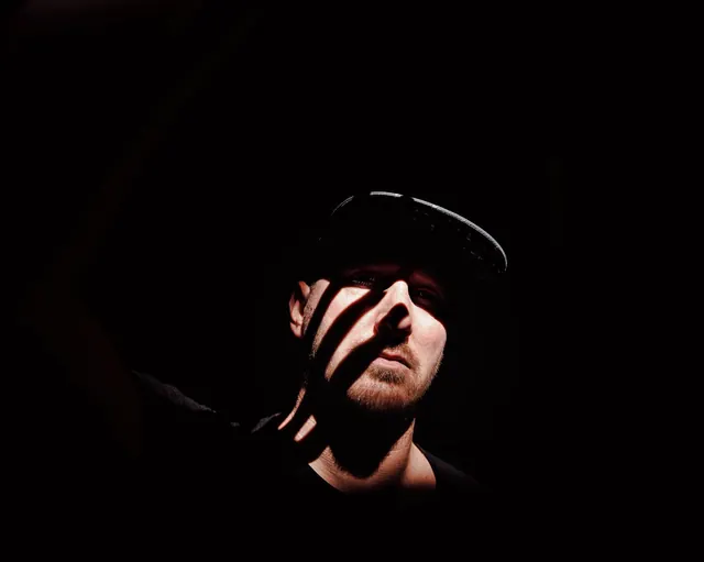 Man in Hat with Light Streak, dark-mode, photographic, dark
