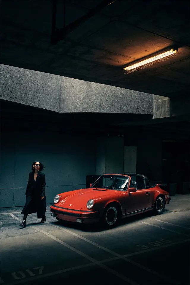 Man and Red Sports Car in Industrial Space, photographic, dark-mode, dark