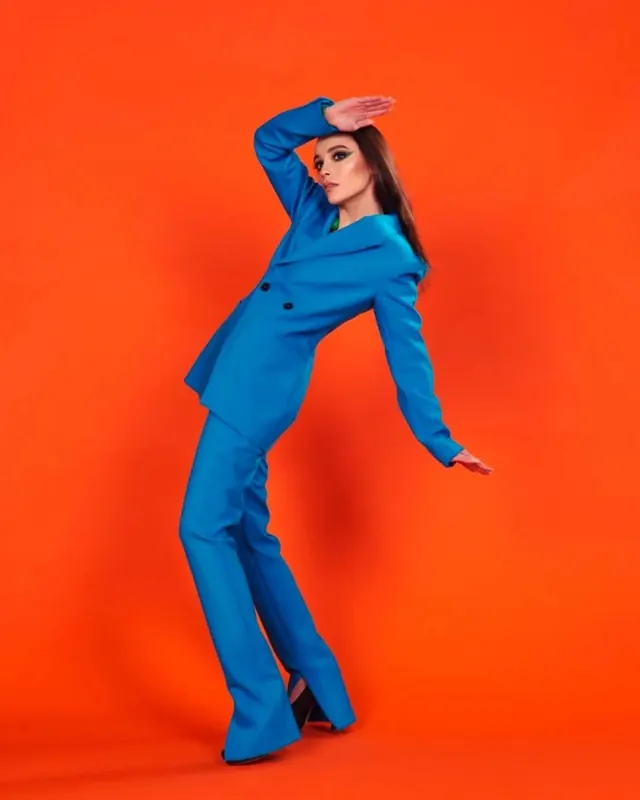Woman in Blue Jumpsuit Against Orange Background, photographic, vibrant
