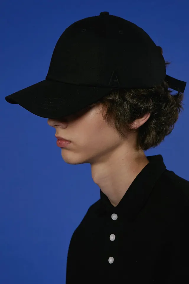 Model Wearing Black Baseball Cap, minimal, photographic, high-contrast