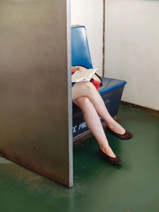 Person Sitting in Blue Chair, photographic, minimal, high-contrast