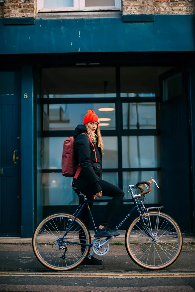 Woman on Bicycle in Urban Setting, photographic, minimal, vibrant