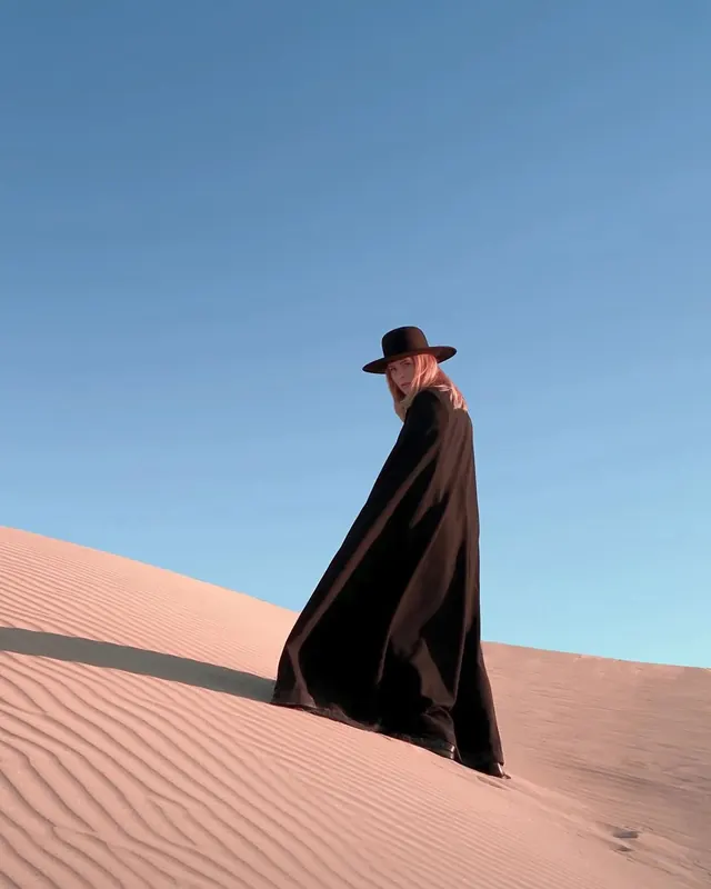 Person in Cloak in Desert, minimal, photographic, high-contrast