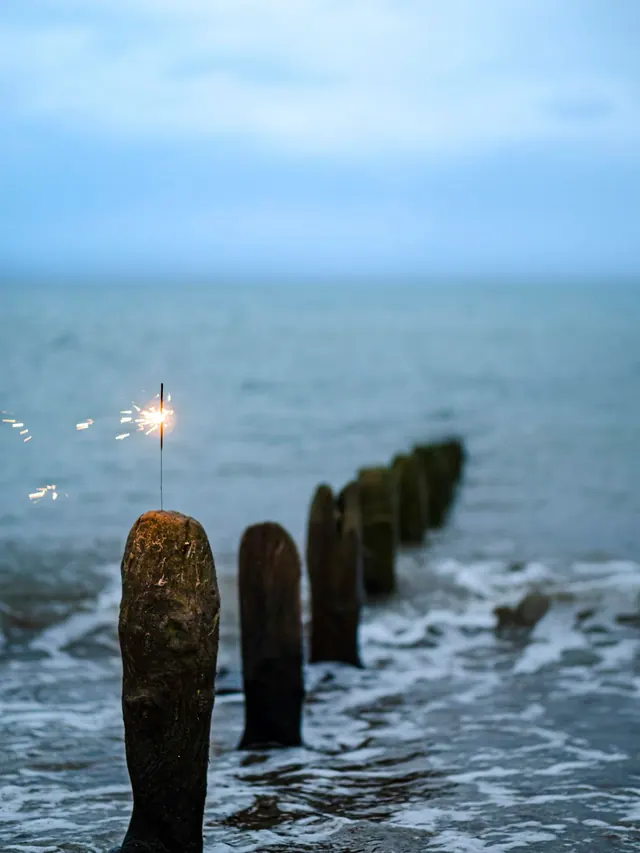 Lit Wooden Post on Beach, photographic, minimal, cool