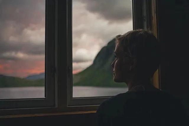 Man Looking Out Window at Mountains, photographic, minimal, dark