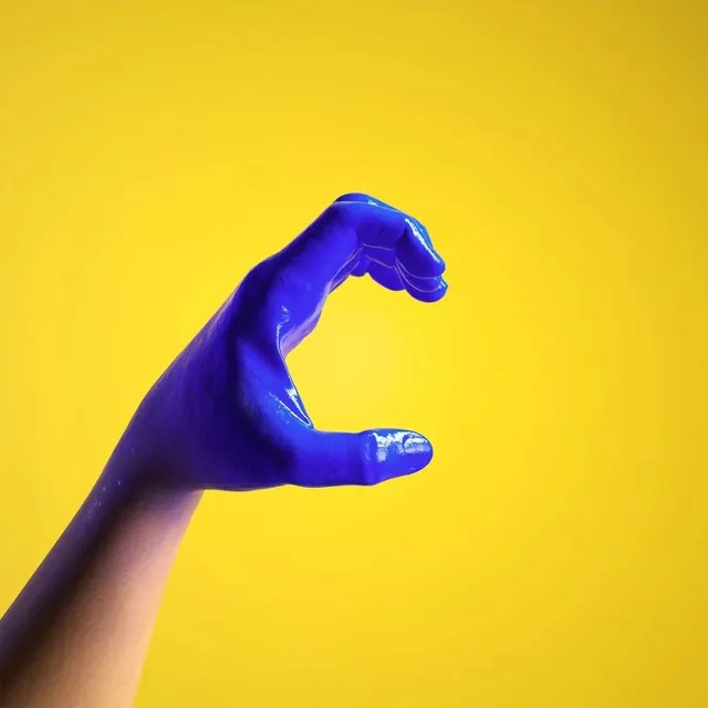 Blue Hand on Yellow Background, minimal, photographic, high-contrast
