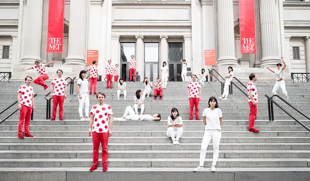 People in Red and White Outfits in Front of Building, photographic, corporate-clean, high-contrast