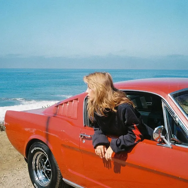 Woman in Red Car by the Ocean, retro, photographic, vibrant