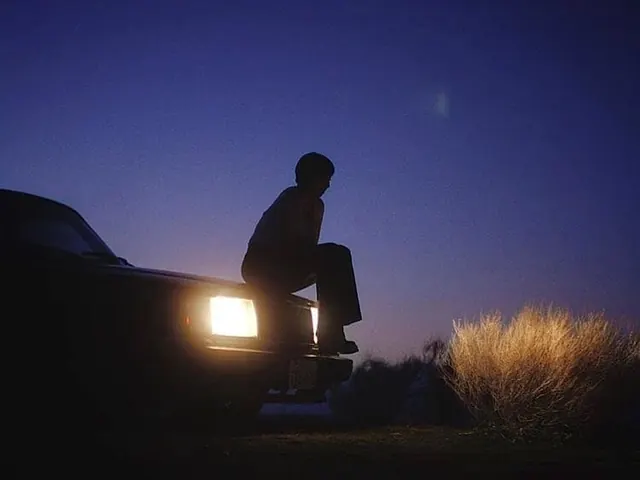 Person Sitting on Car Hood at Dusk, minimal, photographic, dark