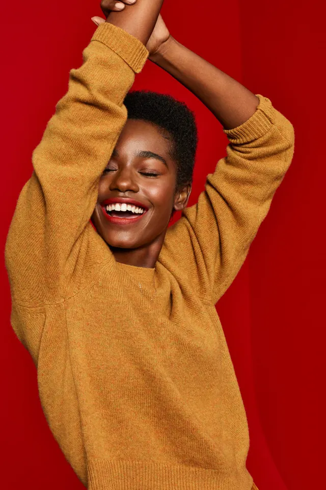 Portrait of a woman in a mustard sweater, flat, vibrant