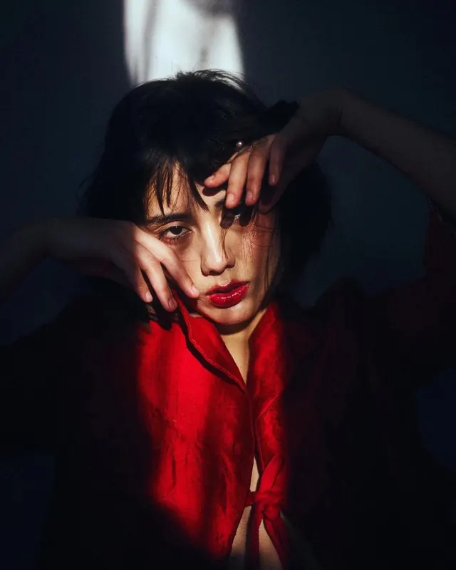 Portrait of a woman in red and black, dark-mode, photographic, dark
